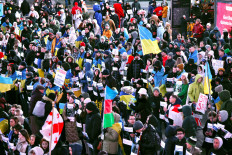People hold banners as they gather to mark one year since Russia's invasion of Ukraine, in Times Square, New York City, on Feb. 24, 2023.