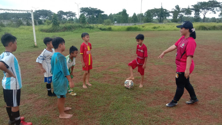 Aprillianty (right), having recently acquired a professional license to be a soccer coach, gives directions to the Garuda Lions FC players on Jan. 29.
