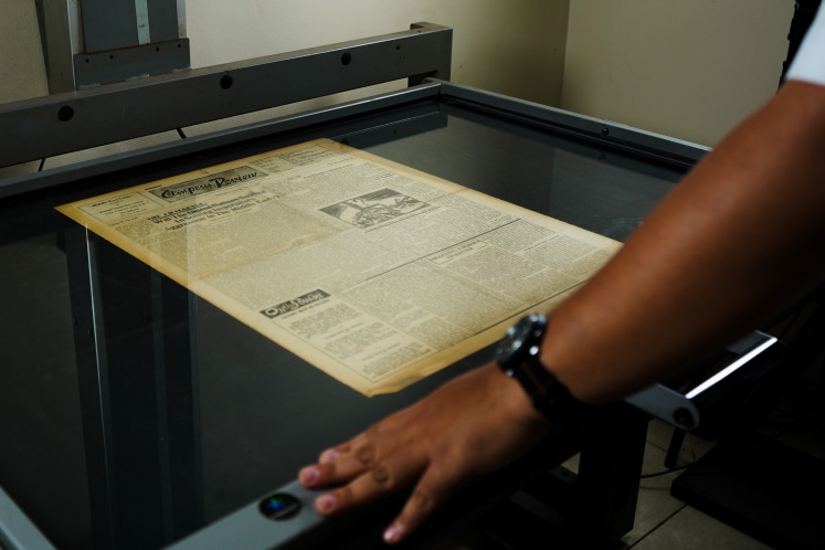 Scanning the headlines: Faisal Huzein digitizes a newspaper at the Preservation Center (JP/Kate Newsome)
