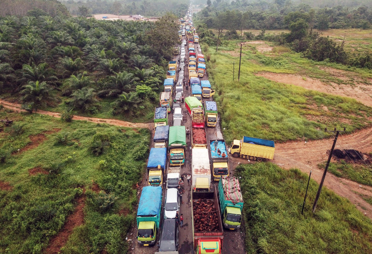 Trucks carrying coal stand out in a traffic gridlock on a highway connecting Sarolangun and Muara Tembesi, Batanghari, Jambi, March 1, 2023. The daily congestion has been blamed on the authorities’ reluctance to ban coal trucks from the national highway.