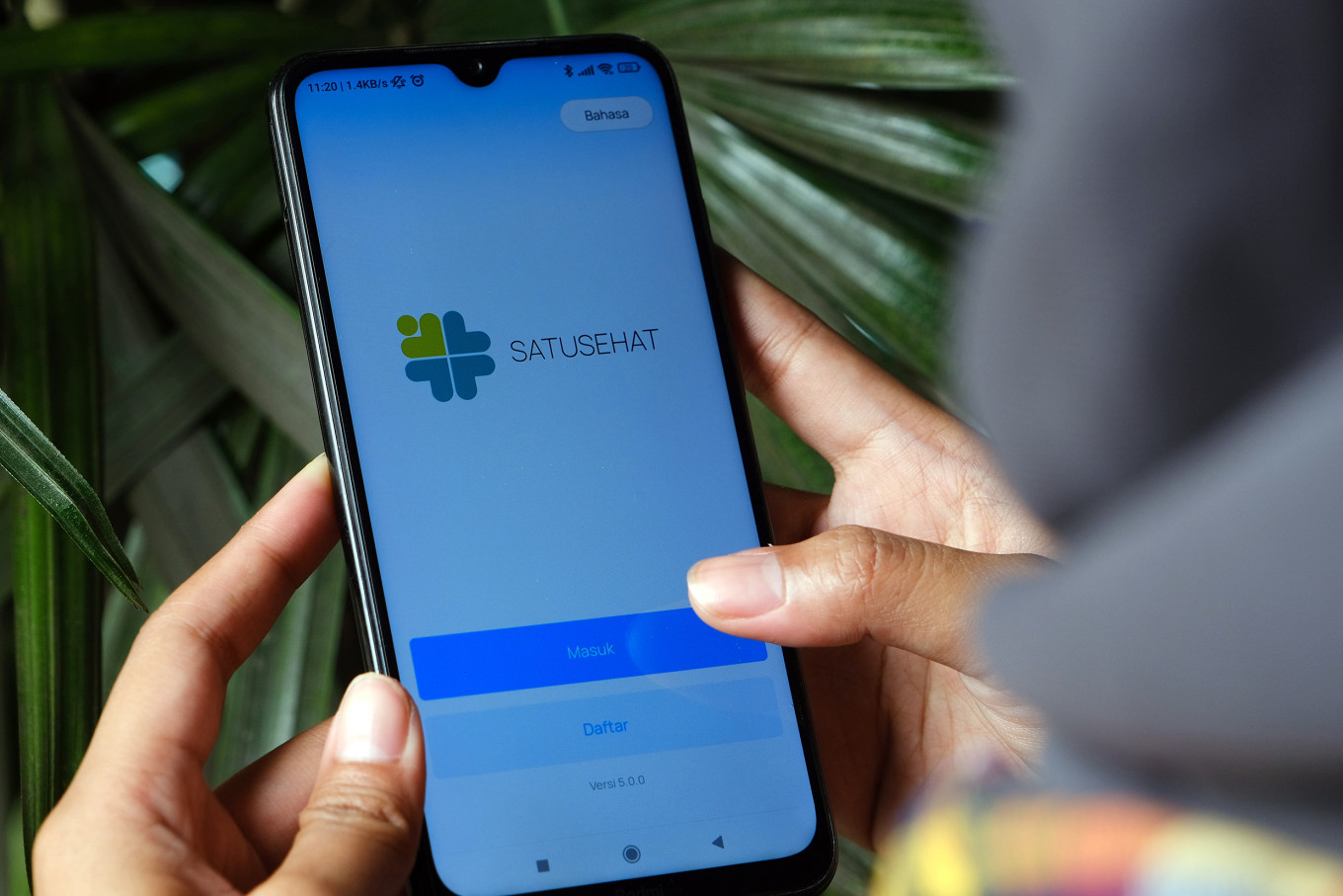 A person opens the Satusehat Mobile app in Pontianak, West Kalimantan, in this file photo. The Health Ministry officially transformed the PeduliLindungi app into SatuSehat Mobile, which users can use to monitor their own state of health. 