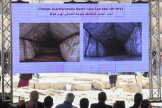 This frame grab taken from AFPTV shows people watching a video about a hidden passage inside the Great Pyramid of Khufu (Cheops) at the Giza Pyramids necropolis on the southwestern outskirts of Cairo on March 2, 2023.