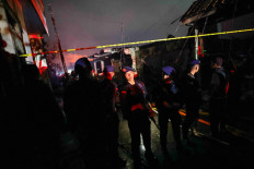 Armed police officers guard an area after a fire broke out at a fuel storage station operated by Indonesia's state energy company Pertamina, in Jakarta, Indonesia, March 3, 2023. REUTERS/Willy Kurniawan