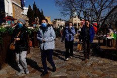 People walk past restaurants in a shopping area in Beijing on Feb. 3, 2023.