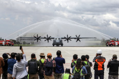 Journalists take photographs of a C-130J-30 Super Hercules aircraft on its arrival at Halim Perdanakusuma Air Force Base in East Jakarta on March 6, 2023. The military transport aircraft, made by the United States’ Lockheed Martin, is the first of five Super Hercules the Defense Ministry has ordered for use by the Indonesian Air Force.