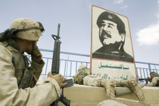 In this file photo dated on April 10, 2003 US marines take position near a portrait of late Iraqi dictator Saddam Hussein in a stadium in Baghdad.