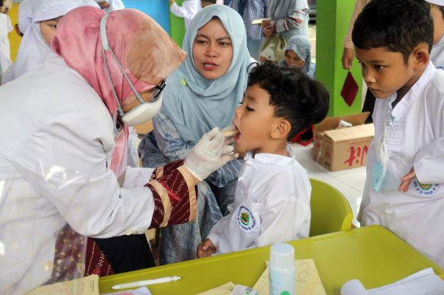 Say 'aahh’: A dentist checks the teeth of a preschool student on Feb. 3 at Al Fatah Kindergarten in Depok, West Java. The activity was part of efforts to raise children’s awareness about dental health.

