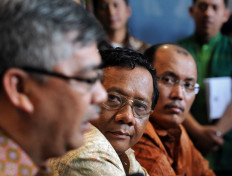 (From left) Then-Constitutional Court justice Akil Mochtar, then-chief justice Mahfud MD and then-secretary general Janedri Gaffar hold a press conference in Jakarta on Dec. 10, 2010.