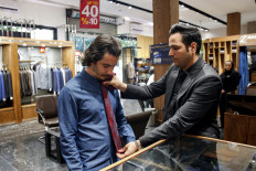 A shopkeeper assists a customer to try on a tie at a clothing shop in the north of Iran's capital Tehran on September 7, 2022. After the fall of the shah in 1979, the Iranian clergy who came to power with Ayatollah Khomeini banned the wearing of neckties because in their eyes they symbolised a subjection to Western culture. Today, ministers, senior civil servants or heads of state-owned companies wear under their suits a shirt with a buttoned, open or Mao collar.
