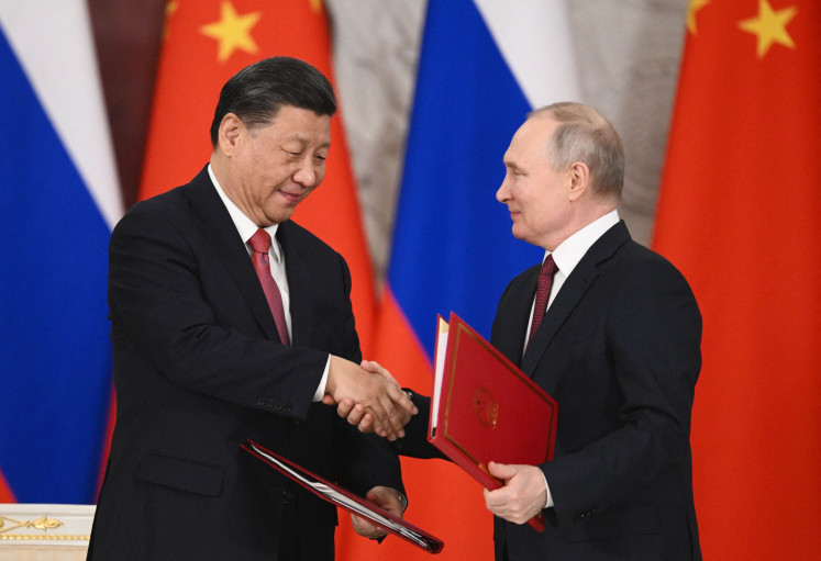 Russian President Vladimir Putin (right) and his Chinese counterpart Xi Jinping shake hands during a signing ceremony following their talks at the Kremlin in Moscow on March 21, 2023.