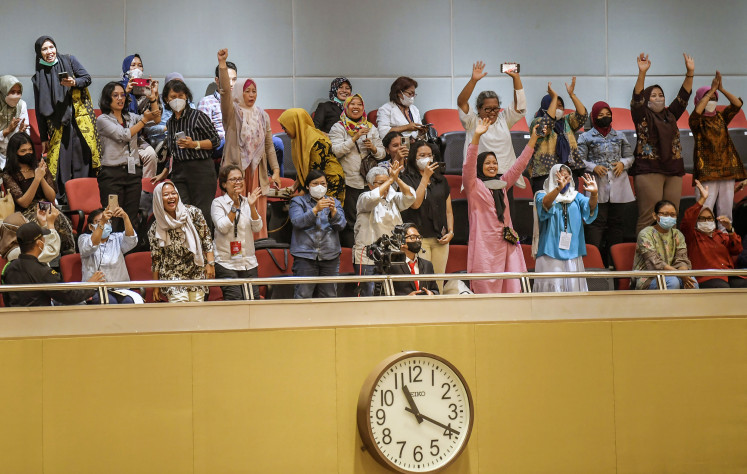 Spectators wave their hands as lawmakers endorse the Domestic Workers Protection Bill as  an initiative draft law during a plenary session on March 21, 2023, at the House of Representatives in Senayan, Central Jakarta. 