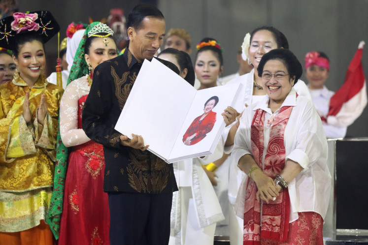 Megawati Sukarnoputri presents a book about herself titled “The Brave Lady“ to President Joko “Jokowi“ Widodo during her birthday celebration in Jakarta on January 23, 2019. 
