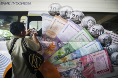 A man withdraws cash at a Bank Indonesia (BI) mobile service point at Pramuka Market in East Jakarta on March 27.