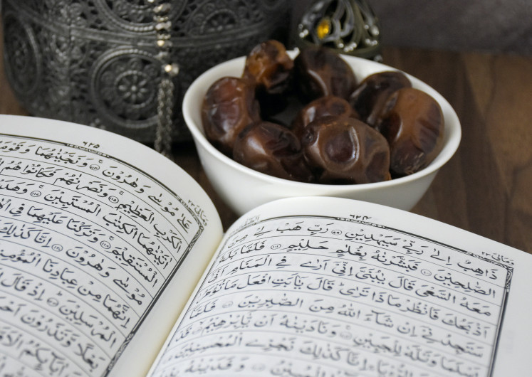 Food for the soul: A plate of dates and a copy of the Quran (Pexels/Khats Cassim)