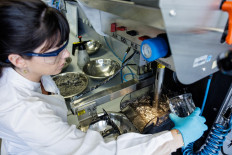 French scientist Anna Vanderbruggen mixes chemicals with a pipette into the graphit recycling system in the Helmholtz Institute Freiberg for Resource Technology in Freiberg, eastern Germany on February 27, 2023.