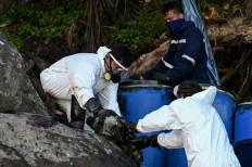 In this picture taken on March 22, 2023, fishermen take part in a clean-up operation from the oil spill of the sunken tanker Princess Empress along the coast in Pola, Oriental Mindoro province.