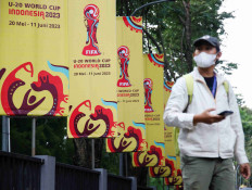 A man walks past FIFA U-20 World Cup banners outside Indonesia's football federation (PSSI) office, after the country was dropped as host of the under-20 soccer World Cup, following outrage among politicians in the predominantly Muslim country about Israel's participation, in Jakarta, Indonesia, March 30, 2023. REUTERS/Willy Kurniawan