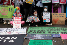 Activists holding placards take part in the Global Climate Strike against climate change in Jakarta on March 3, 2023.