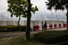 People walk along Victoria Harbour in Hung Hom district of Hong Kong, China, on March 30, 2023.