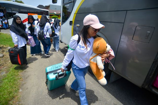 Around 100 female migrant workers from West Sumatra and neighboring Jambi, Riau and South Sumatra prepare to board a bus on March 15, 2023 in West Sumatra’s provincial capital Padang to depart for jobs in Malaysia.