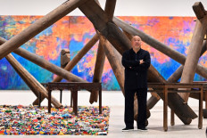 Chinese artist Ai Weiwei poses in front of his art pieces displayed during the press preview for the exhibition 'Ai Weiwei: making sense' at the Design Museum, in London, on April 4, 2023.