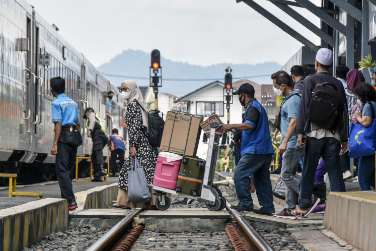 Travelers board a train at Tasikmalaya Station, West Java, on April 5, 2023. 