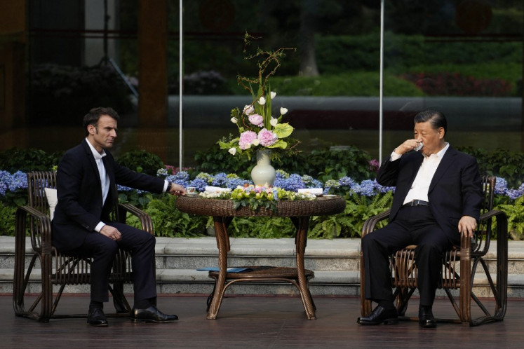 Chinese President Xi Jinping (right) and French President Emmanuel Macron attend a tea ceremony at the Guandong province governor's residence in Guangzhou on April 7, 2023. 
