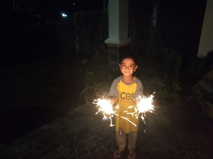 Playing with fire: A younger, 5-year-old Arraya holds sparklers during New Year's Eve at his house in Bandung. (Courtesy of Haura)
