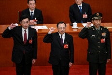 (Left-right) Newly-elected Chinese state councilor Qin Gang, state councilor and secretary-general of the State Council Wu Zhenglong, state councilor Li Shangfu swear an oath after they were elected during the fifth plenary session of the National People's Congress (NPC) at the Great Hall of the People in Beijing on March 12, 2023.
