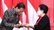 Food for thought: President Joko “Jokowi” Widodo (left) receives a slice of rice cone from Indonesian Democratic Party of Struggle (PDI-P) chairwoman Megawati Soekarnoputri during the opening of the party’s national executive meeting in Jakarta, on June 21, 2022.