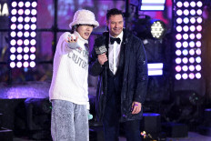 J-Hope and Ryan Seacrest speak on stage during the Times Square New Year's Eve 2023 Celebration on December 31, 2022 in New York City.
