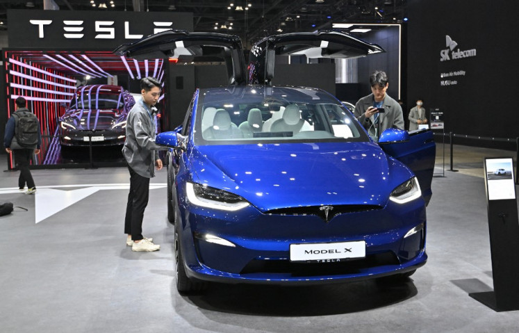 Visitors look at a Tesla Model X during a press preview of the 2023 Seoul Mobility Show at the KINTEX exhibition hall in Goyang, South Korea, on March 30, 2023.
