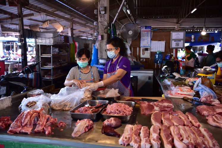 Vendors prepare pork for sale on Jan. 15, 2022 at a market in the southern Thailand province of Narathiwat
