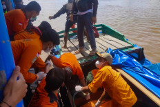 This handout picture taken and released on April 28, 2023 by the Indonesia Search and Rescue Agency (BASARNAS) shows rescue workers moving victim's bodies after a passenger boat overturned shortly after leaving Tembilahan port in Indragiri Hilir Regency a day earlier. 