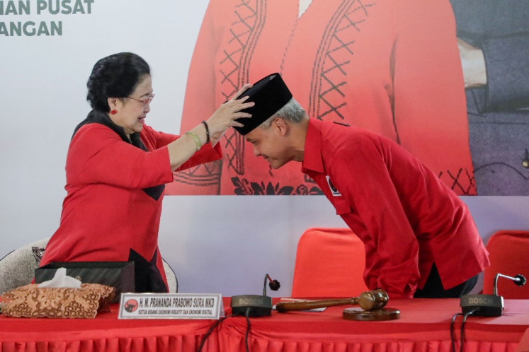 Indonesian Democratic Party of Struggle (PDI-P) chairman Megawati Soekarnoputri (left) symbolically places a ‘peci’ hat on the head of politician Ganjar Pranowo during an event on April 21, 2023, in Bogor, West Java, where the ruling party announced it had selected Ganjar as its presidential candidate for the 2024 election.

