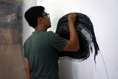 Striking: Mujahidin works on a painting for the Your Silence Will Not Protect You exhibition (Courtesy of Mujahidin)
