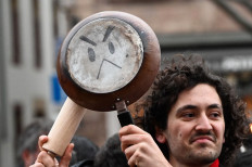 A demonstrator takes part in a pan-banging protest during French President Emmanuel Macron’s televised address to the nation, after he signed into law a pensions reform, in Strasbourg, eastern France on April 17, 2023. Macron on April 15 addressed France for the first time since signing into law his controversial pension reform, facing warnings the political and social crisis it sparked is not over. Macron signed the legislation just hours after the banner change to raise the retirement age from 62 to 64 had been validated by the constitutional court on April 14, prompting accusations he was smuggling the law through in the dead of night.

