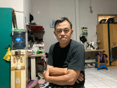 Getting by: A photograph of Endang at his house, on May 1. Shown in the background are the sewing machines that his son uses as a clothing vendor when he is not out taking food orders.(JP/Anindito Ariwandono)
