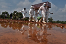 In this file photograph taken on August 10, 2021, grave diggers carry the coffin of a victim who died from COVID-19 coronavirus for burial at a cemetery in Bekasi, West Java.