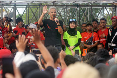Central Java Governor Ganjar Pranowo (center), accompanied by his wife Siti Atikoh Supriyanti, greets members of the public on May 7, 2023 while exercising at Alun-Alun Jember, a recreational park in Jember, East Java. The presidential candidate of the Indonesian Democratic Party of Struggle (PDI-P) was visiting the city to woo voters ahead of the 2024 campaign season.
