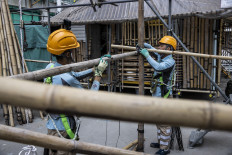 This picture taken in Hong Kong on March 2, 2023 shows students Ho Cheuk-wai (R) and Mo Jia-Yu (L) tying bamboo polls together at the Hong Kong Institute of Construction during a bamboo scaffolding class. The world's most skyscraper-laden metropolis is also one of the last remaining major cities to use bamboo scaffolding for modern construction and building repair.
