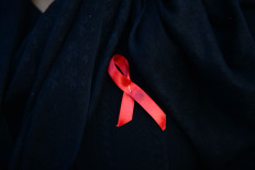 In this file photograph taken on November 30, 2016, a Nepalese woman wearing an AIDS awareness ribbon takes part in an event to mark the eve of World AIDS Day in Kathmandu.