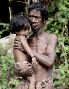 Defender of nature: An Orang Rimba tribesman carries his child near their camp in Batang Hari regency, Jambi, on May 19, 2017. The Orang Rimba are an indigenous community of an estimated 70 million people and play a pivotal role in environmental protection.