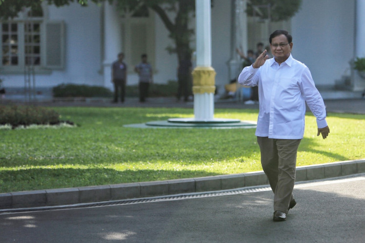 Chairman of Gerindra party, Prabowo Subianto, waves to the press while arriving at the State Palace, Jakarta on Oct. 21, 2019. 