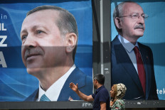 A couple walks past billboards with the portrait of Turkish President Recep Tayyip Erdogan (L) and with the portrait of Republican People's Party (CHP) leader and presidential candidate, Kemal Kilicdaroglu (R) in Sanliurfa, Turkey on April 28, 2023.