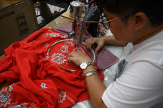 This picture taken on April 7, 2023 shows a worker sewing a kebaya, a traditional outfit worn by women in Southeast Asia, for sale at a shop in Kuala Lumpur. Brunei, Indonesia, Malaysia, Singapore and Thailand agreed to jointly nominate the “kebaya“ to be inscribed on UNESCO's list of Intangible Cultural Heritage for 2023.
