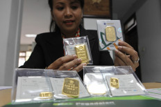 An employee shows gold at the Pegadaian Office, Jalan Bendungan Hilir Raya, Jakarta, Monday (17/02). PT Pegadaian (Persero) in 2013 Pegadaian gold sales reached around Rp 1.3 trillion. This amount increased compared to 2012 which was around Rp 1.05 trillion. And in 2014 targeting gold sales to Rp 2.5 trillion. 