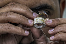 In this picture taken on February 19, 2023 a smith uses a loupe magnifier to inspect a jewellery piece at the Azza Fahmy workshop in the 6th of October industrial zone southwest of Egypt's capital.