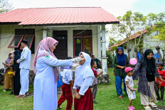 A health worker administers the polio vaccine to a child during a vaccination drive in Pulo Aceh, a remote island in Aceh, on Dec. 6, 2022.