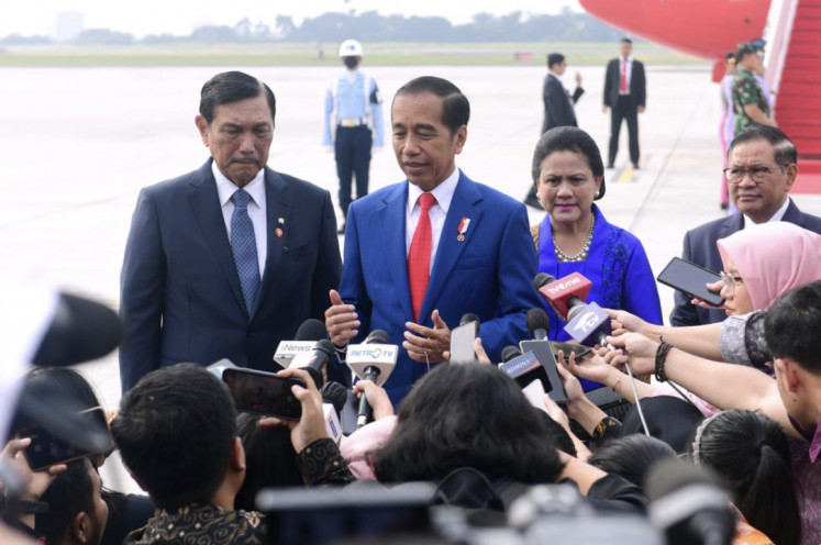 President Joko “Jokowi“ Widodo, joined by Coordinating Maritime Affairs and Investment Minister Luhut Panjaitan (left) and First Lady Iriana, speaks in a press briefing on the tarmac of the Halim Perdanakusumah Air Base in Jakarta on May 19.